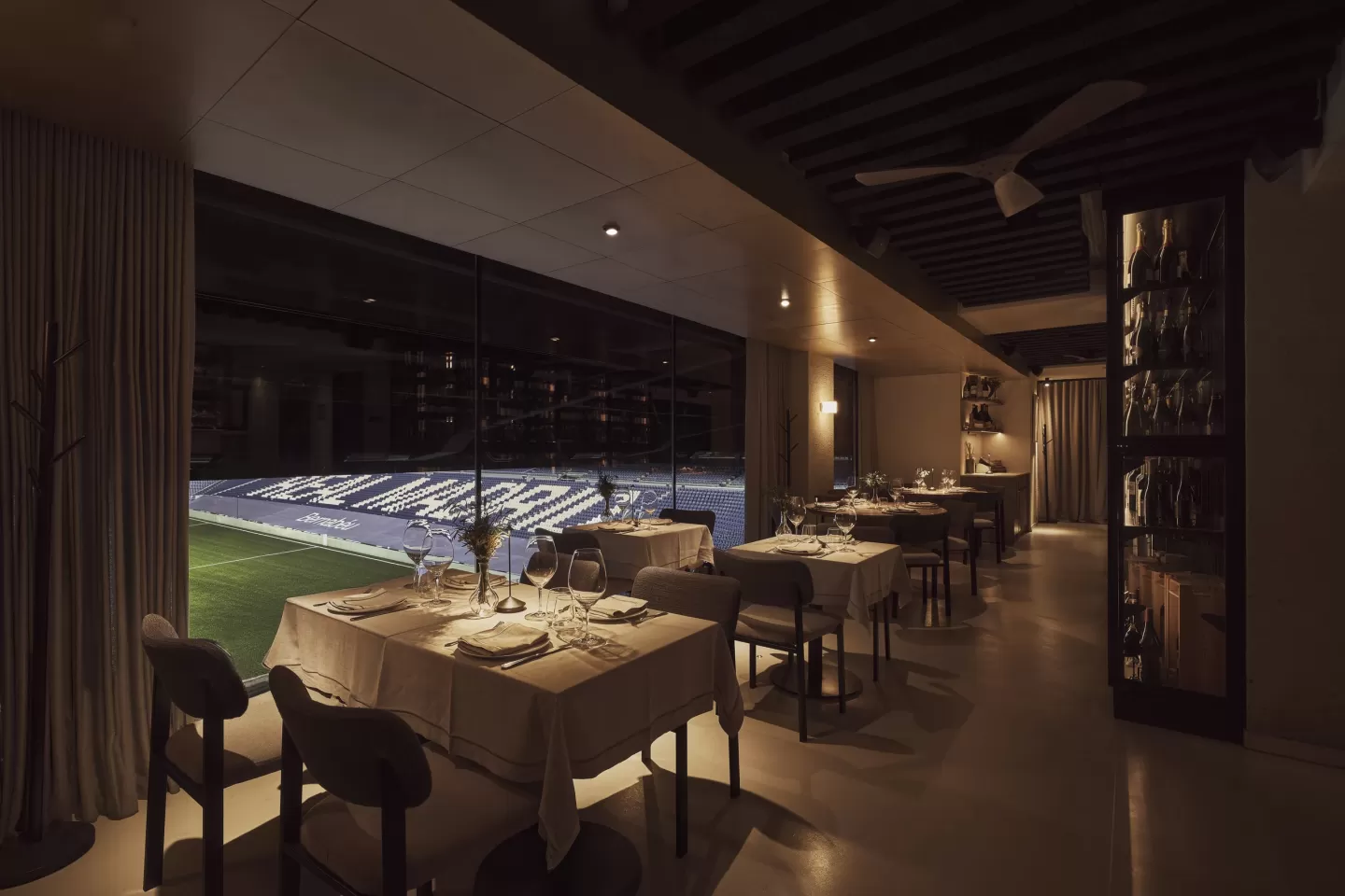 Comedor de Arzábal Bernabéu con ventanal al césped del estadio Santiago Bernabéu