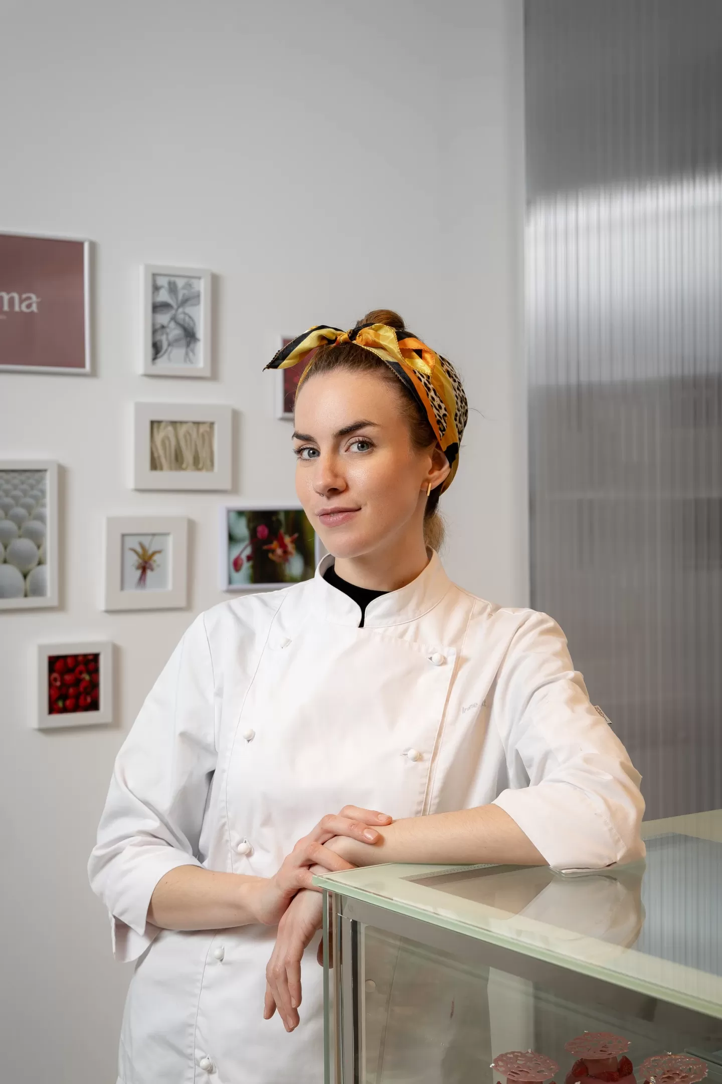 La pastelera Irene Amat apoyada en la vitrina de su pastelería ITAMA en Madrid