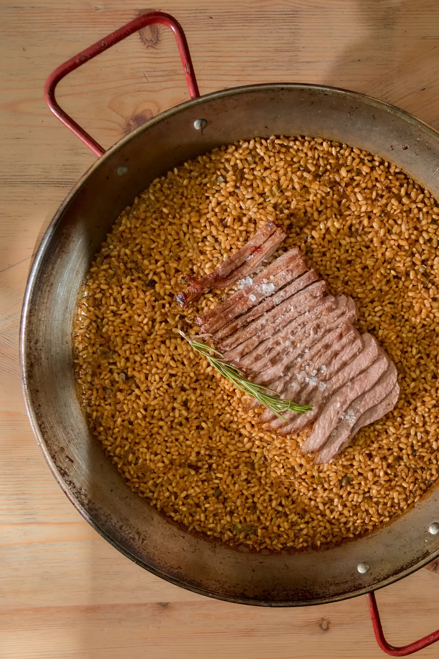 Arroz ibérico con secreto servido en paella en El Jardín de Arzábal