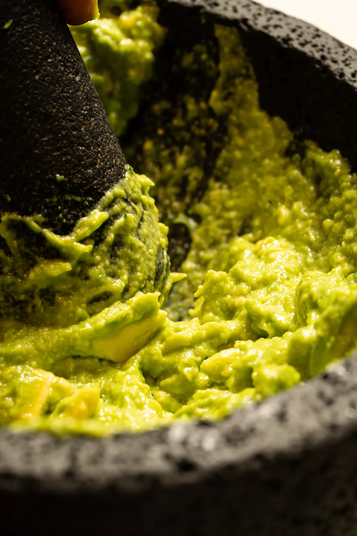 Detalle del guacamole machacado con tejolote en el molcajete
